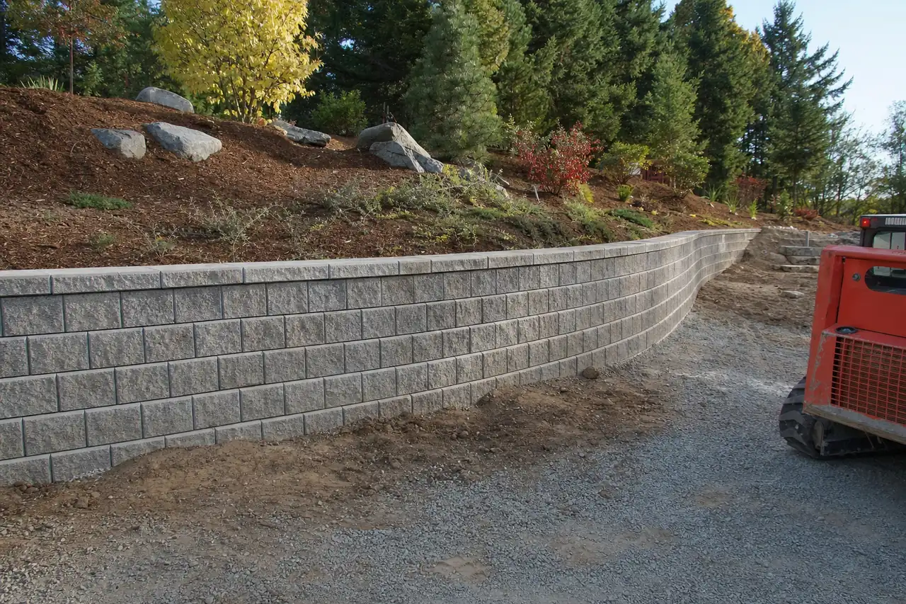 A new rendered block retaining wall holding back a sloping suburban garden — retaining walls, Launceston. Illustrative example.